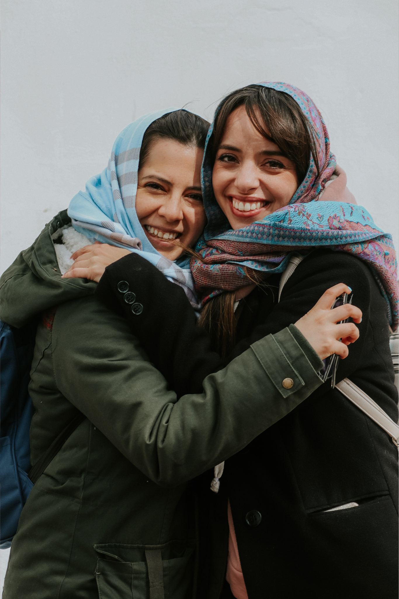 queerasyou-lgbtqia-vertical-1366x2048-smiling-women-embrace-wearing-head-scarves-outside